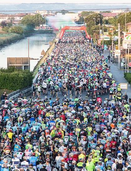 Ciclisti partecipano a una gara su strada affollata.