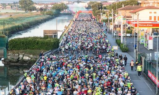 Ciclisti partecipano a una gara su strada affollata.