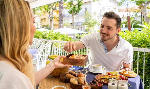 Frühstück im Freien mit Brot, Obst und Kaffee.