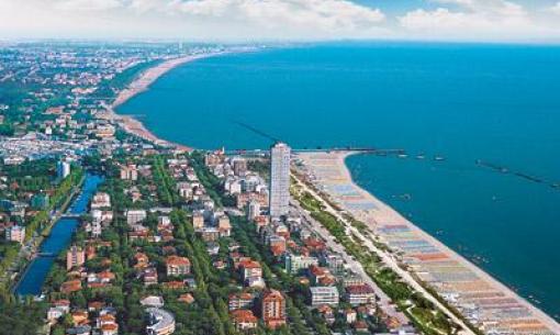 Luftaufnahme einer Küstenstadt mit Strand und Meer.