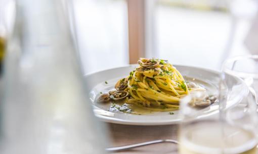 Piatto di spaghetti alle vongole con prezzemolo fresco.