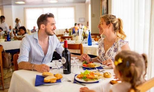 Famille heureuse dînant dans un restaurant lumineux.