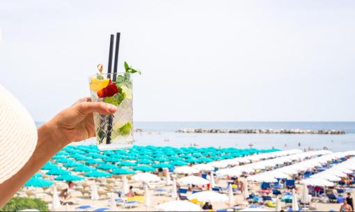 Strandcocktail mit bunten Sonnenschirmen und Meerblick.