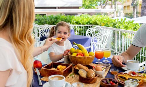 Familienfrühstück im Freien mit Obst und Getränken.