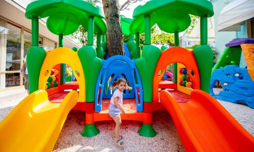 Child playing on a colorful slide at the playground.