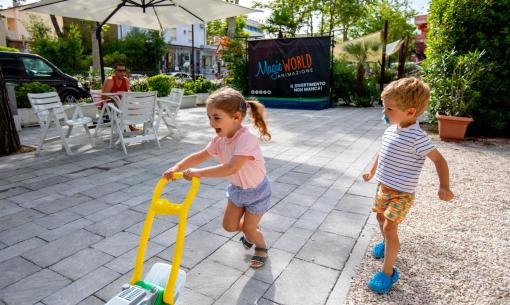 Children happily play outside with a toy.