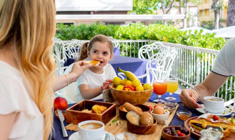 Colazione in famiglia all'aperto con frutta e bevande.