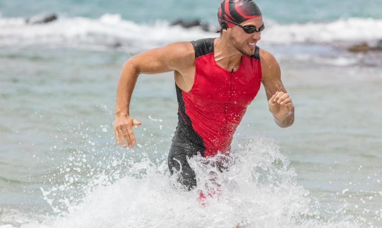 Athlet kommt aus dem Wasser bei einem Triathlonrennen.