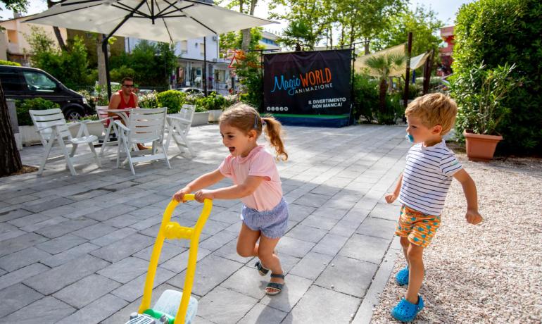 Children happily play outside with a toy.