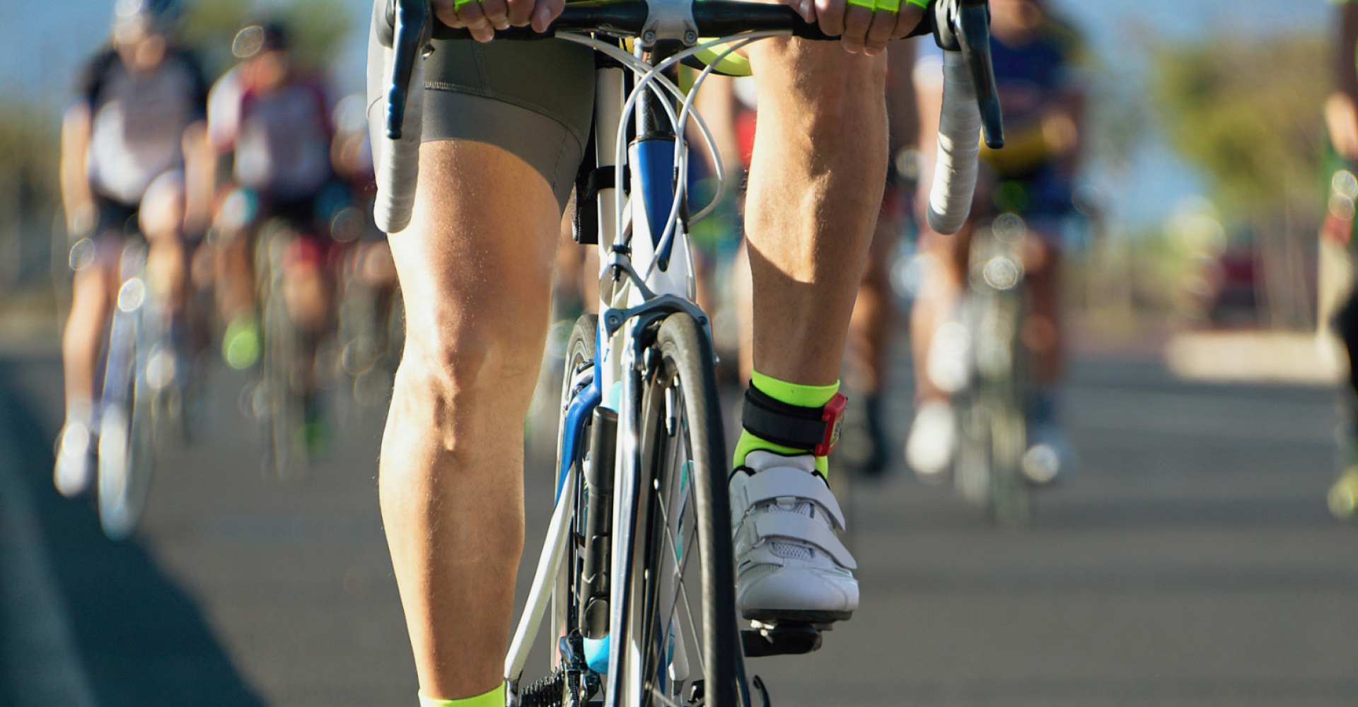 Gruppo di ciclisti in gara su strada, concentrati e in movimento.