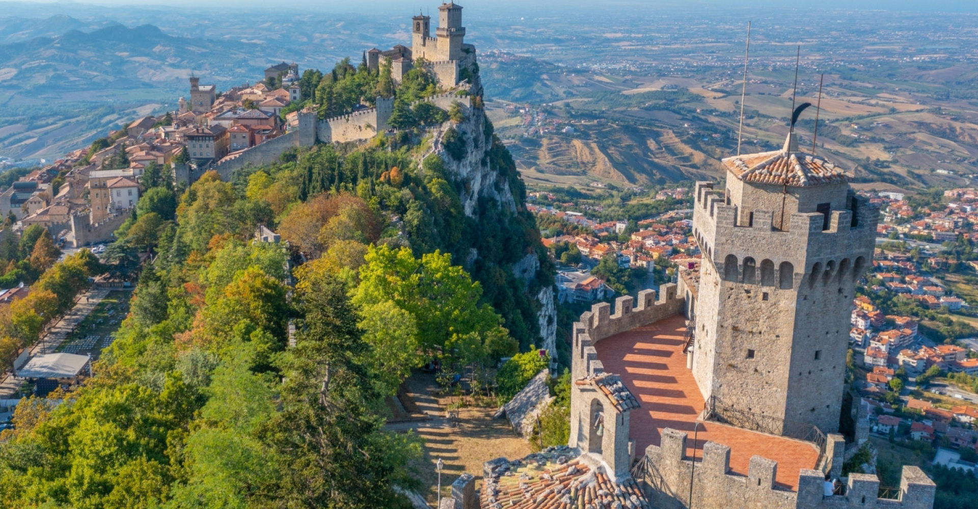 Vista panoramica di San Marino con torri medievali e paesaggio collinare.