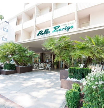 Hotel Bella Zurigo con palme all'ingresso e area esterna accogliente.