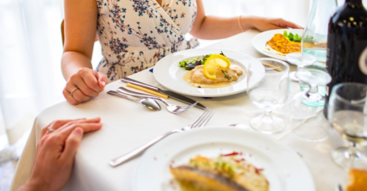 Cena elegante con piatti raffinati e atmosfera intima in un ristorante.